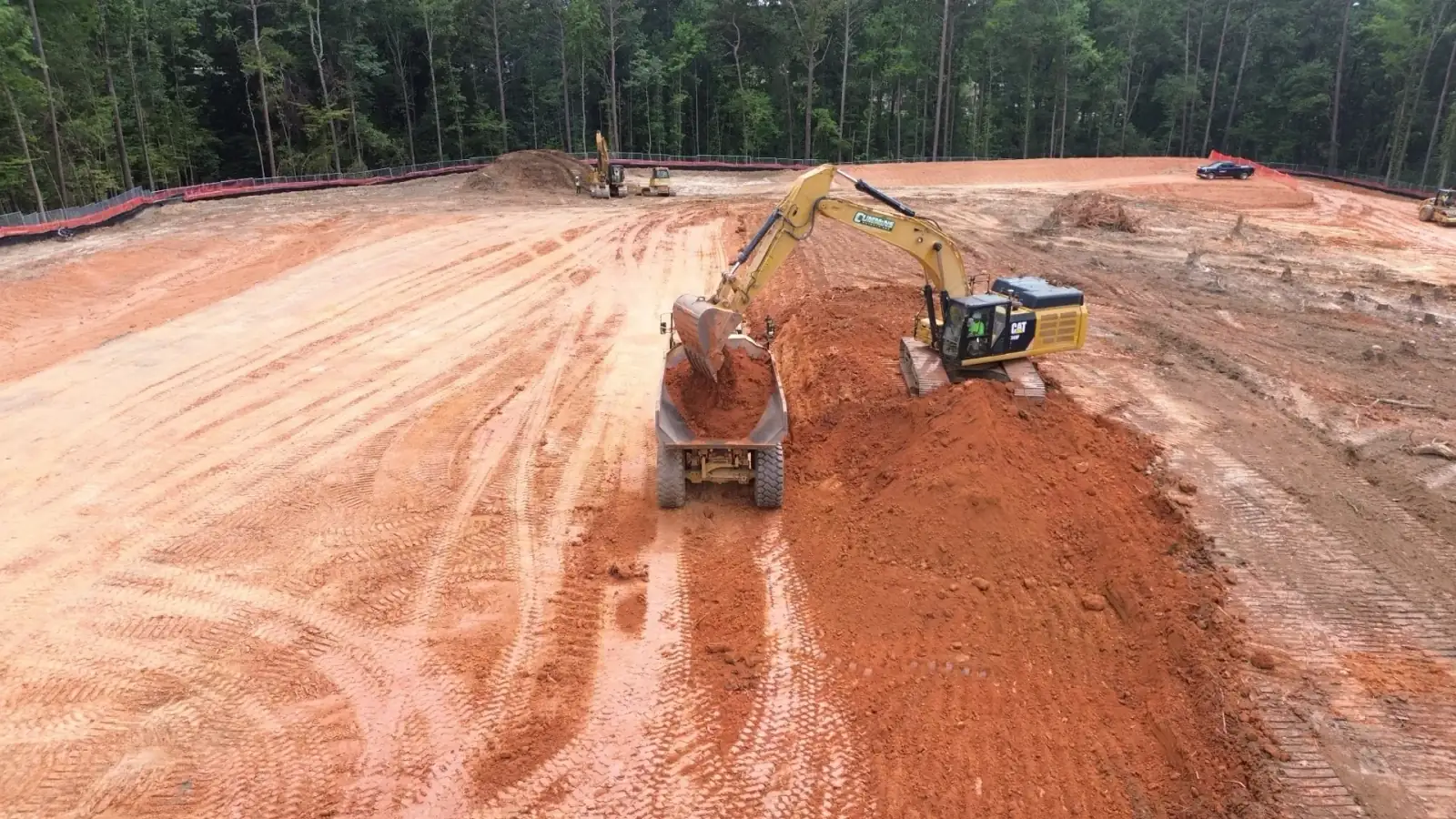 Excavator loading an articulated haul truck during earthwork at the TCSG-411 CDL pad in Dallas, Georgia